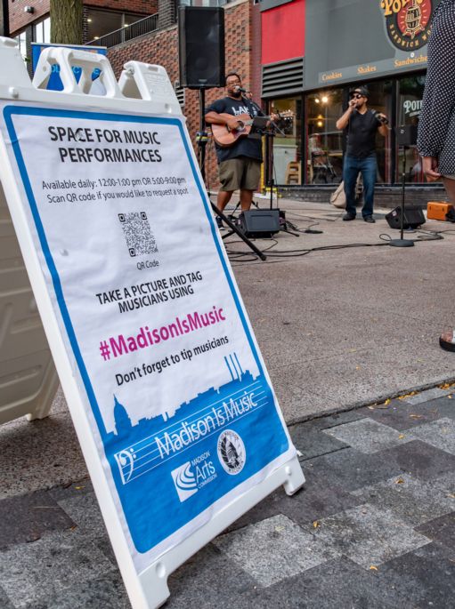 A sandwich board with Madison is Music text. 