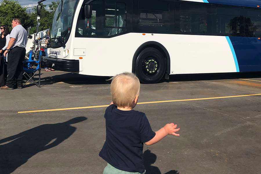 A little boy runs towards the electric bus on display