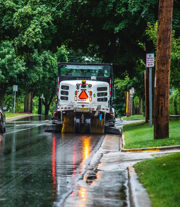 Street sweeper working in a Thursday CSCL area during a rainy day.
